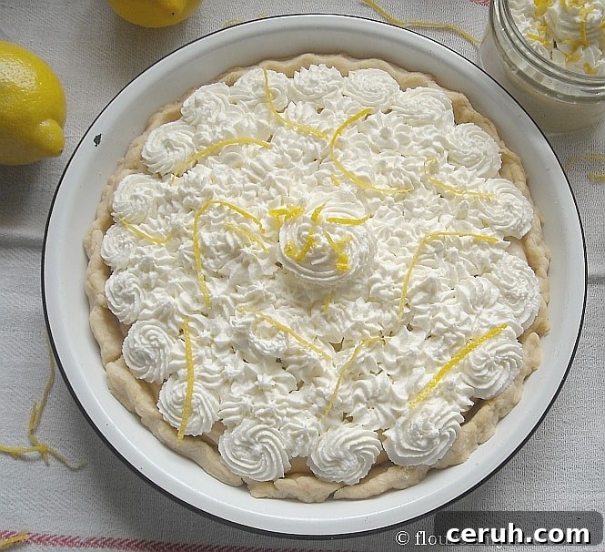 overhead photo of a pie topped with whipped cream swirls and lemon zest