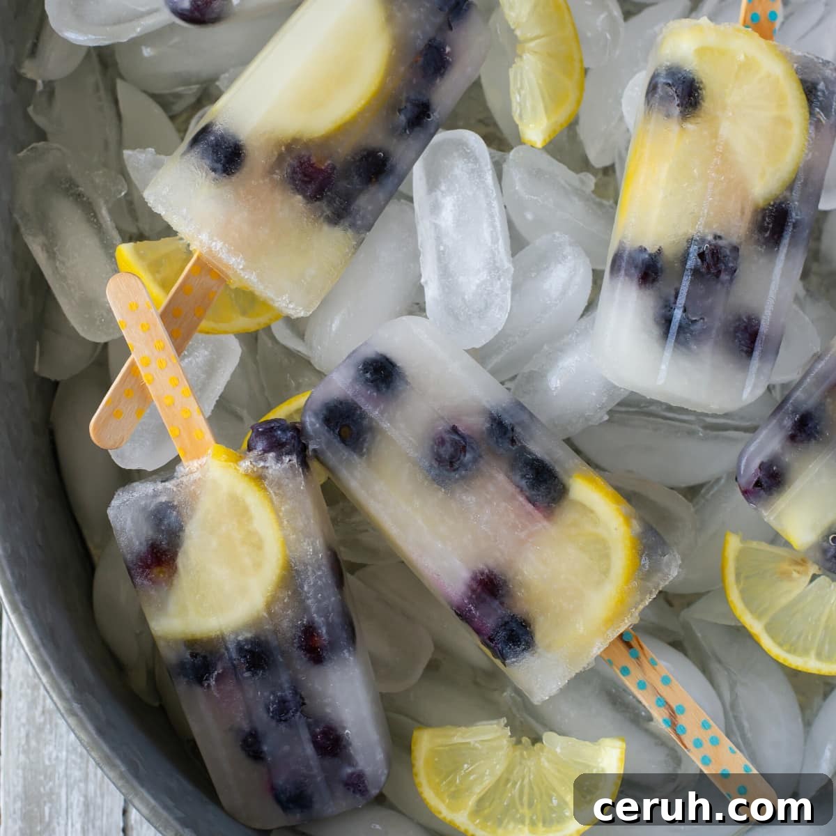 Homemade ice pops in a tin serving tray stacked on a bed of ice cubes.