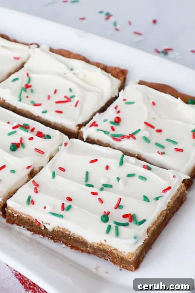 Gingerbread cookie squares topped with cream cheese frosting and sprinkles.