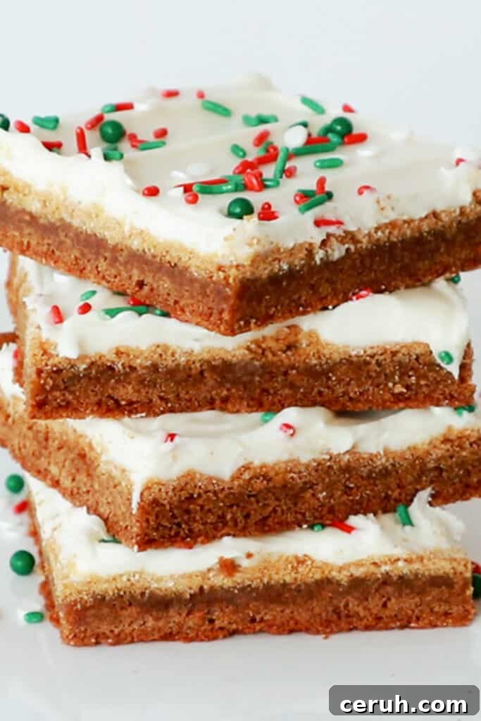 A stack of gingerbread cookie bars topped with icing and sprinkles.