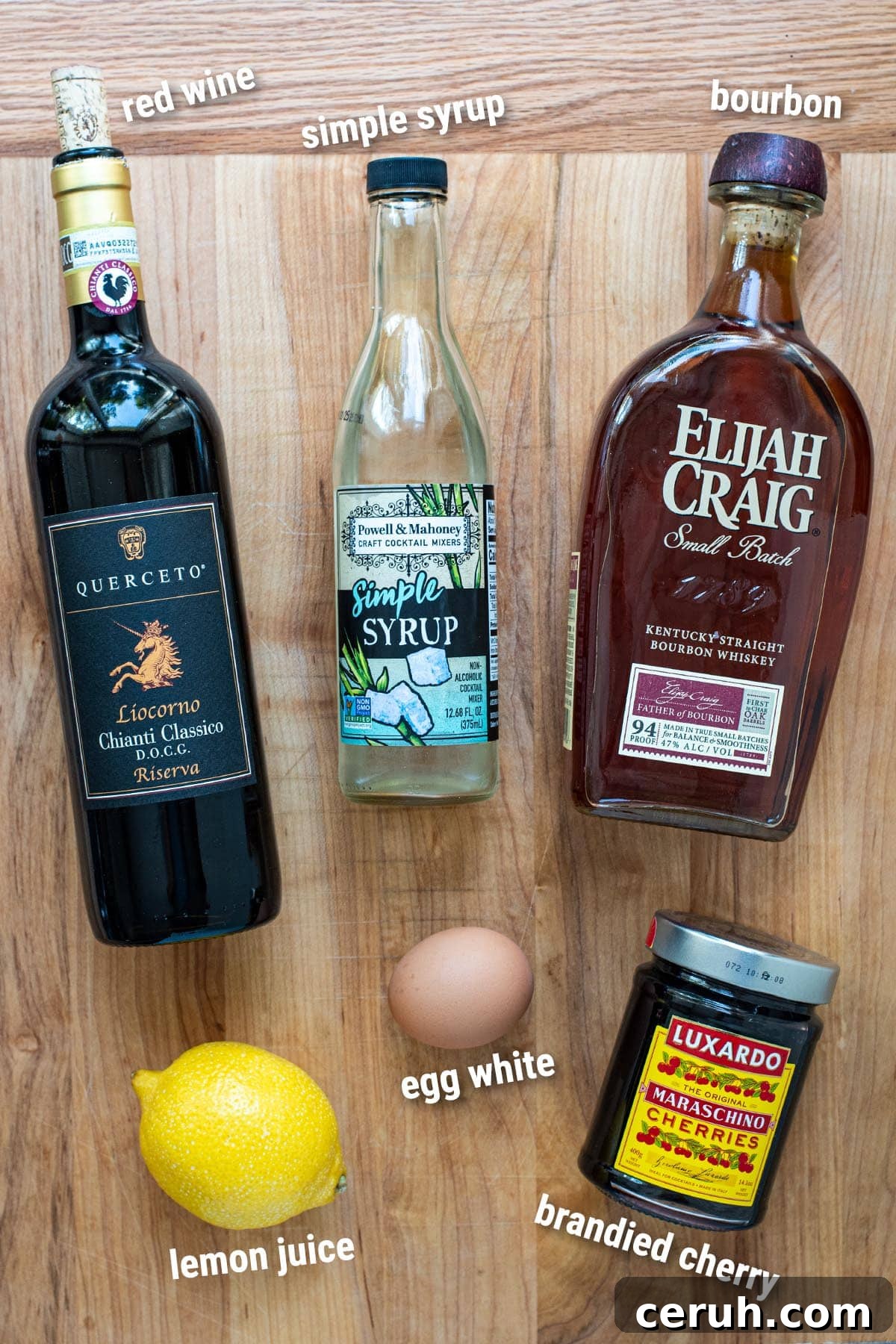 Ingredients for a New York Sour laid out on a cutting board.