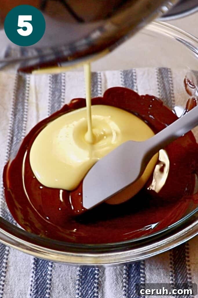 pouring pate au bombe into melted chocolate