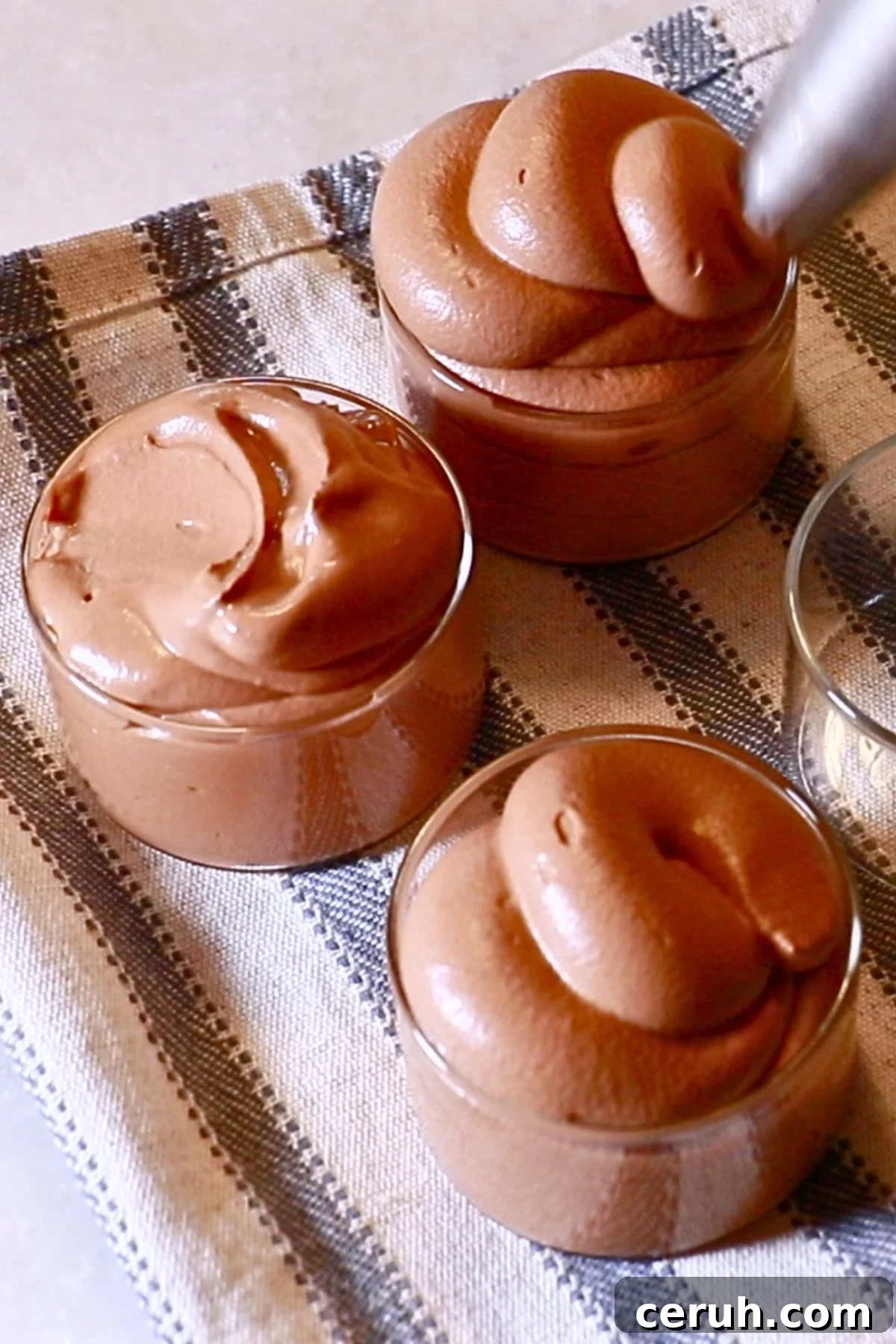 piping chocolate mousse into glasses