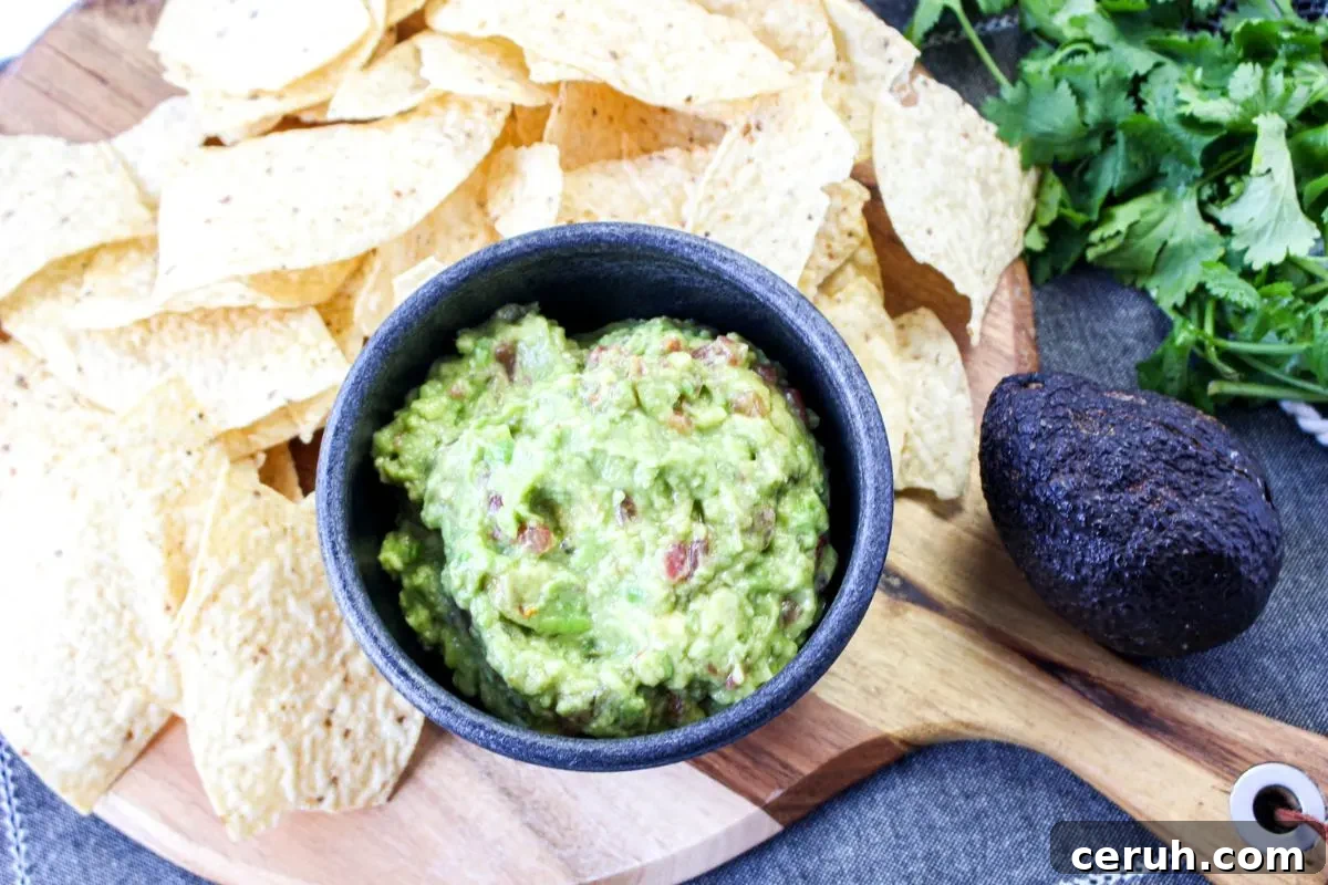 A bowl of guacamole with chips.