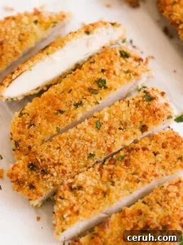 hero shot of an oven baked chicken cutlet that has been sliced into pieces to reveal the juicy insides.