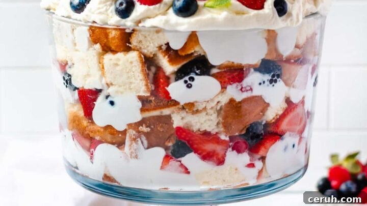 a gluten free trifle with layers of cake, whipped cream and berries