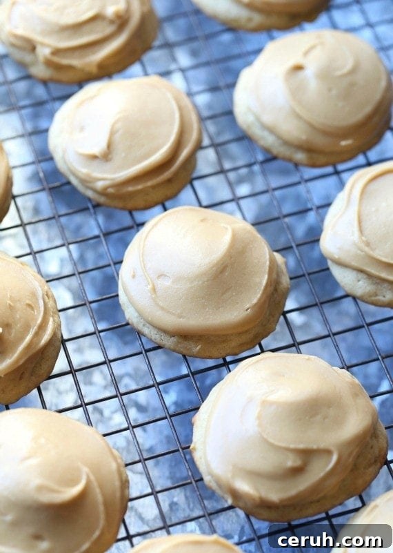 This easy banana cookies recipe makes soft, sweet cookies loaded with banana flavor, topped with caramel frosting. Mix the dough in one bowl! Banana cookies topped with caramel frosting on a wire rack.