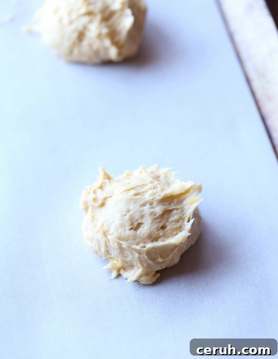 Mix and scoop the cookie dough. Drops of banana cookie dough on a lined baking sheet.