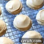 Banana cookies topped with caramel frosting on a wire rack.