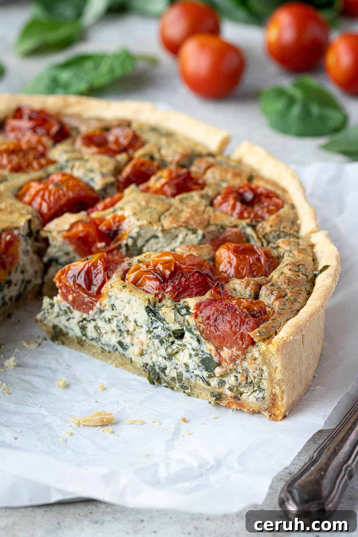 Close up of a slice of vegan tomato spinach quiche.