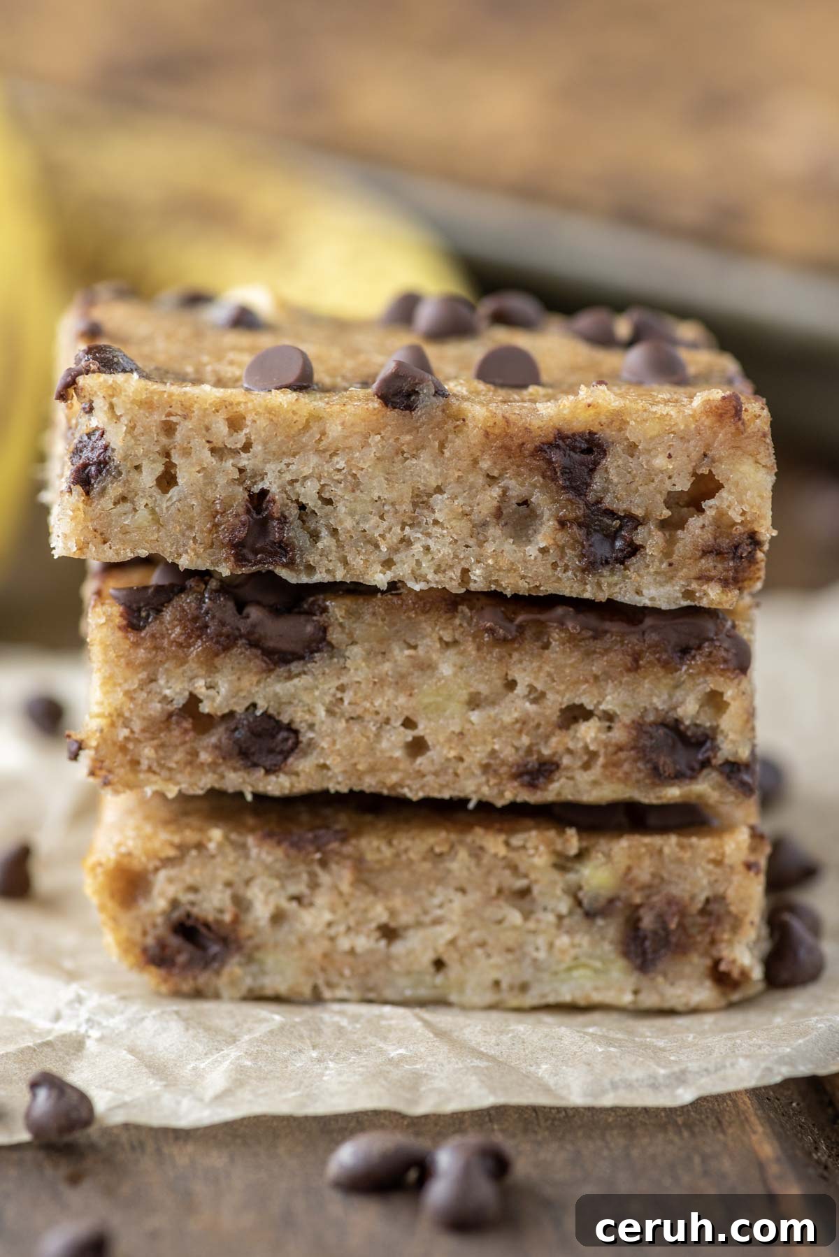 3 stacked chocolate chip banana bars on parchment paper