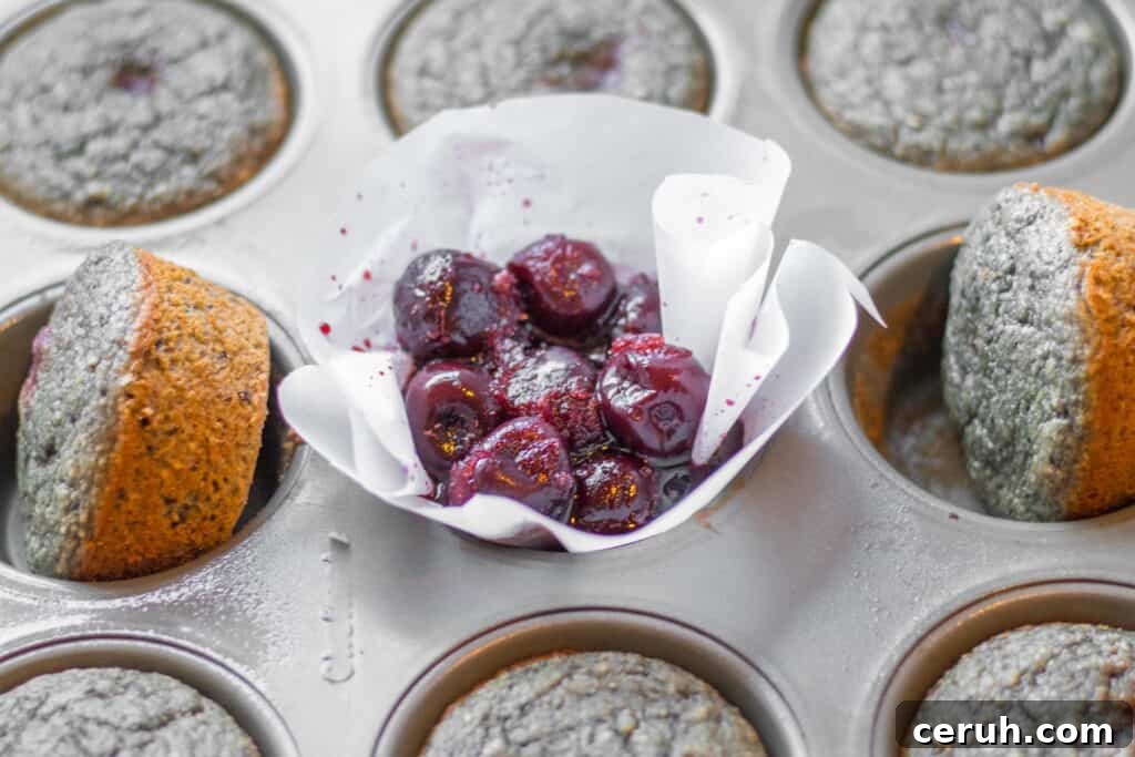 frozen cherries in a muffin tin with baked muffins