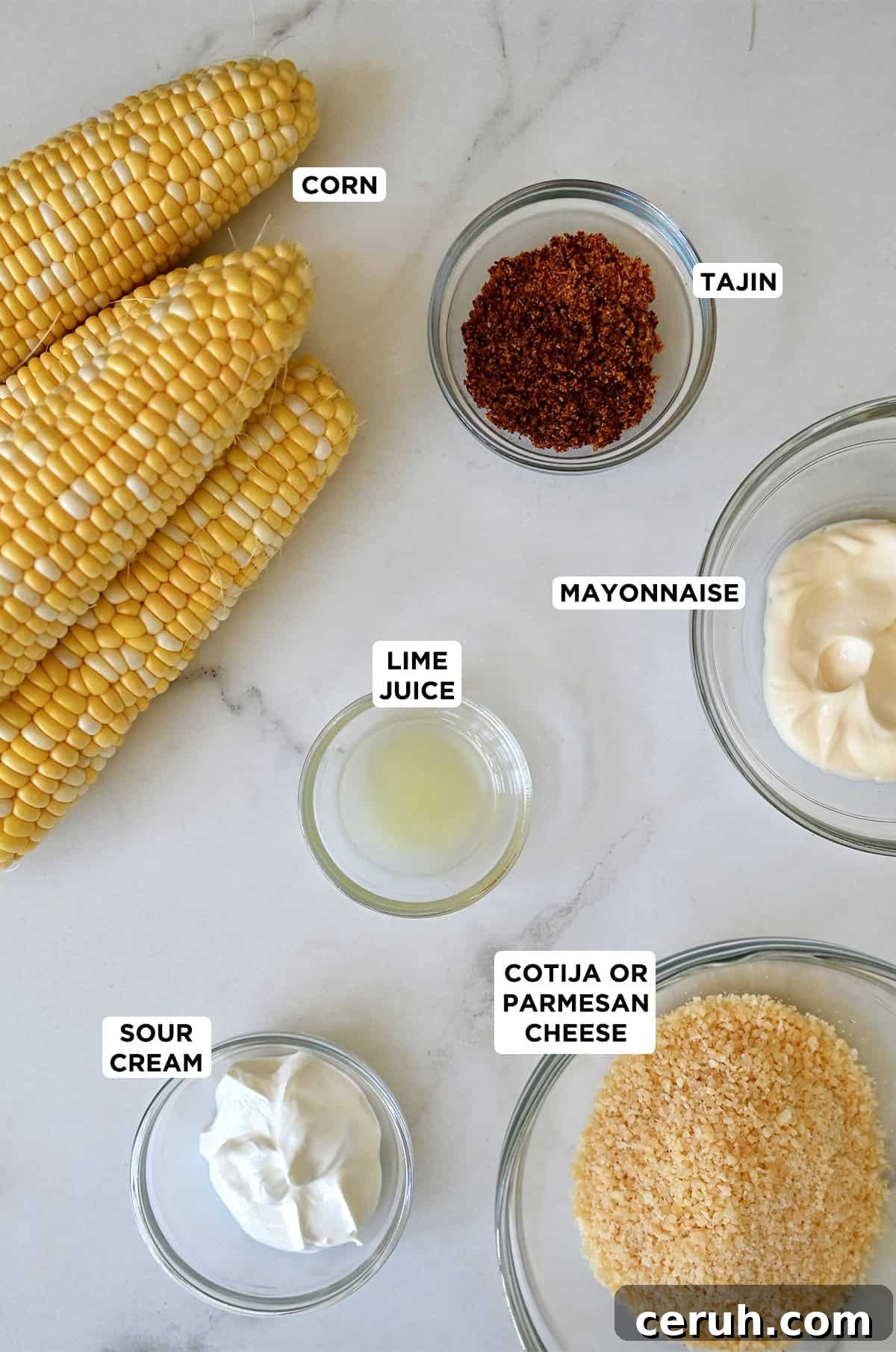 Ingredients to make Mexican street corn: sweet corn on the cob, mayo, sour cream, Cotija cheese, lime juice and chili powder.