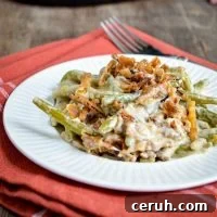 A plate of green bean casserole, served on a small plate on top of cloth napkin.