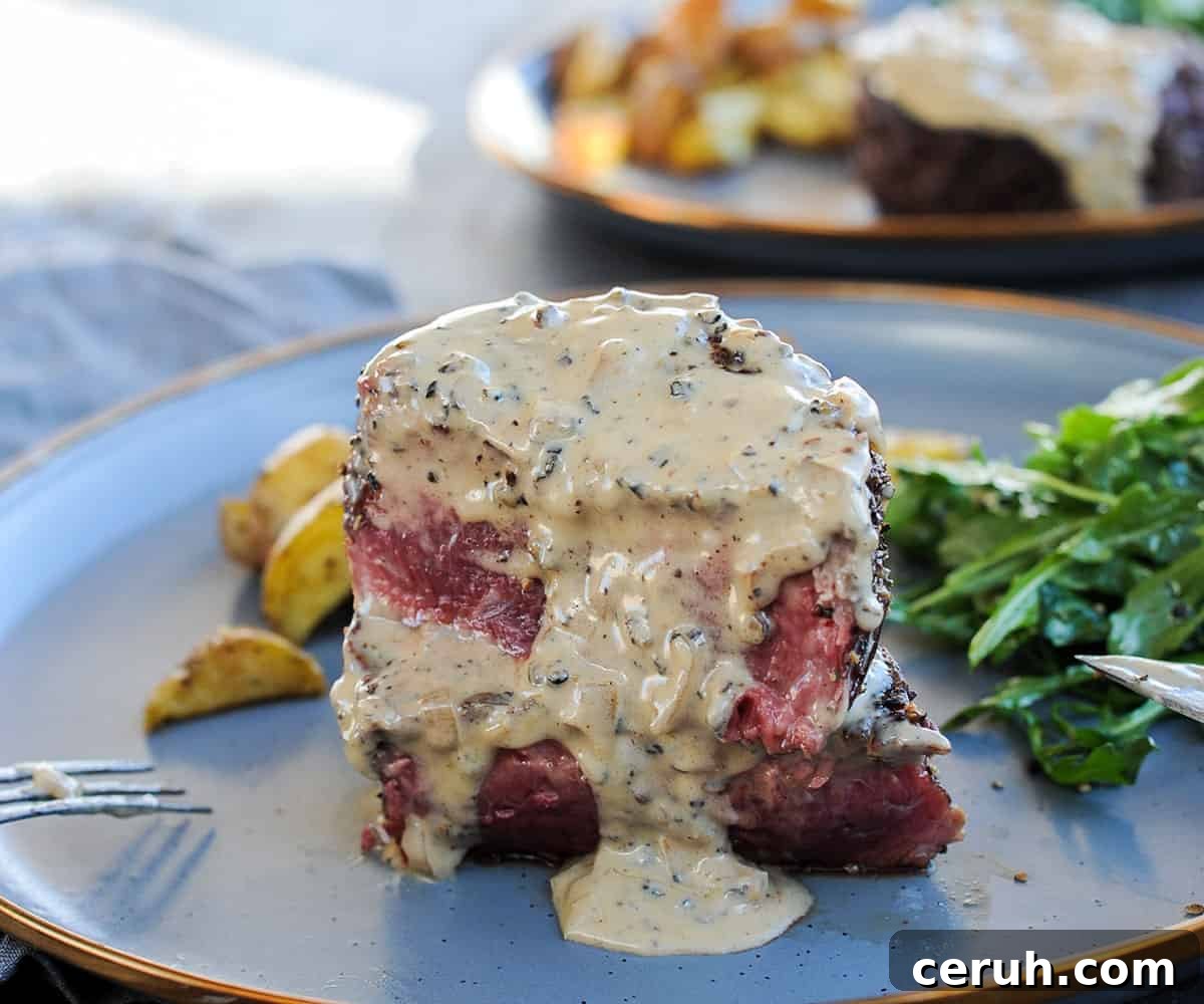 sliced filet mignon steak with peppercorn sauce drizzled on top.