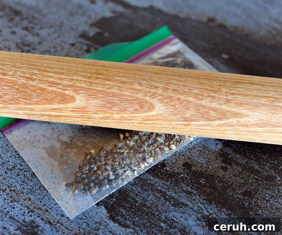 rolling pin crushing peppercorns in baggie.