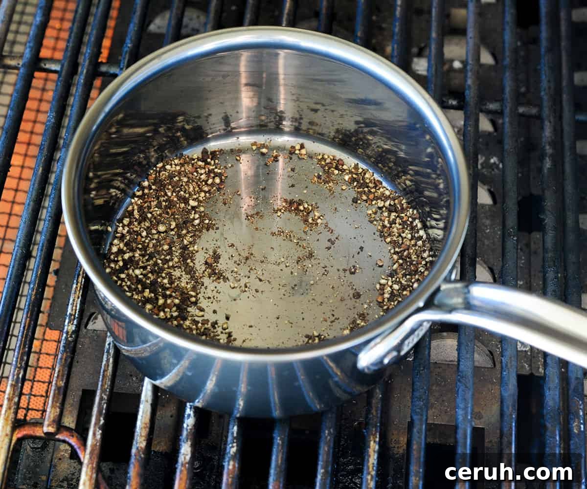 Crushed peppercorns toasting in pot on grill.