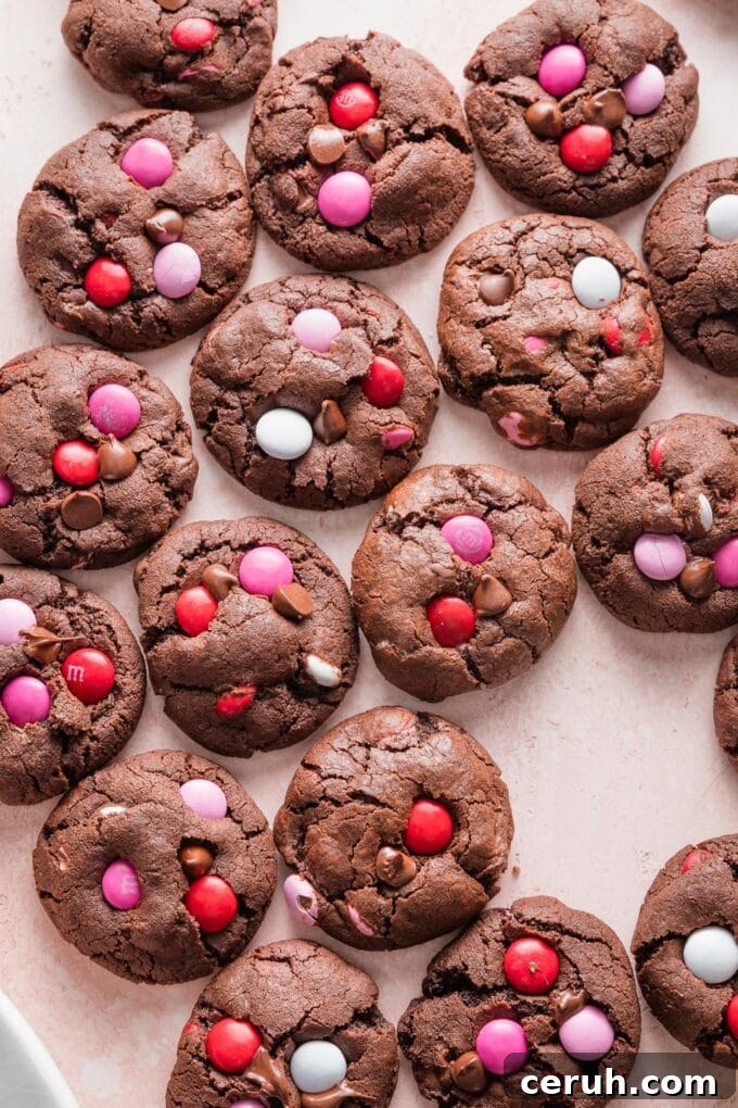 Pink countertop filled with rows of double chocolate Valentines cookies.