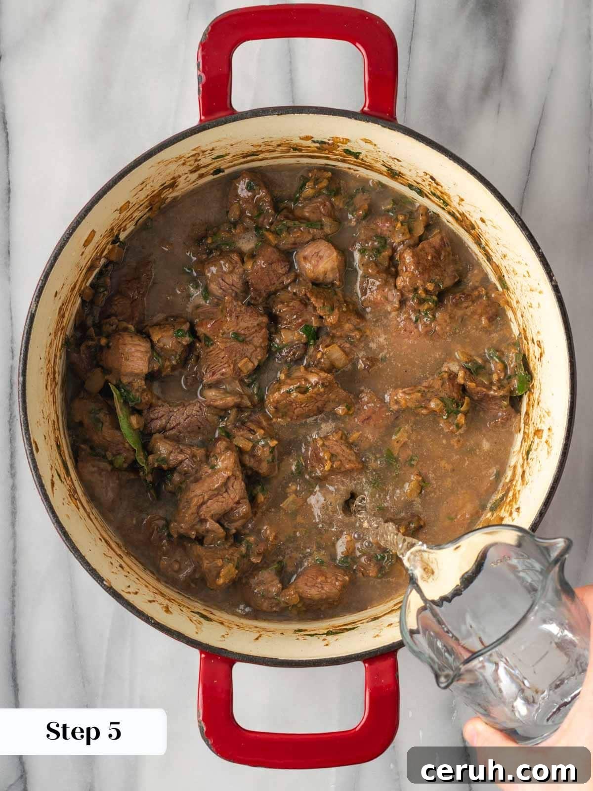 Adding water to beef stew cooking.