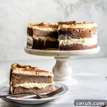 snickerdoodle cake on cake stand next to a slice of the cake