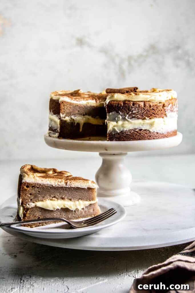 snickerdoodle cake on cake stand next to a slice of the cake