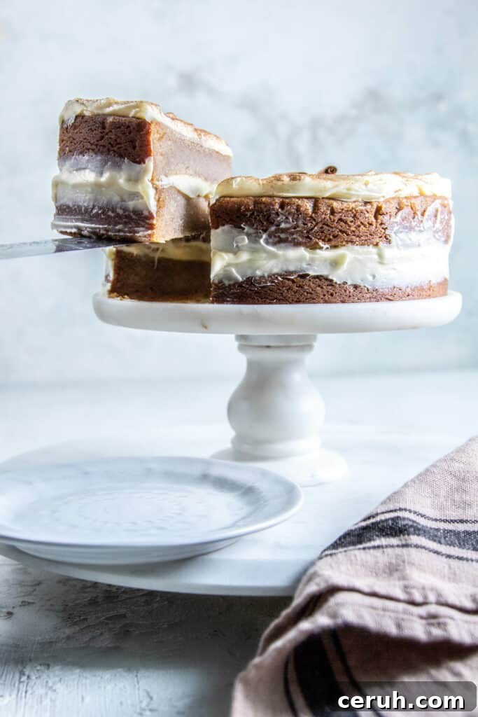 snickerdoodle cake on cake stand with hand cutting slice
