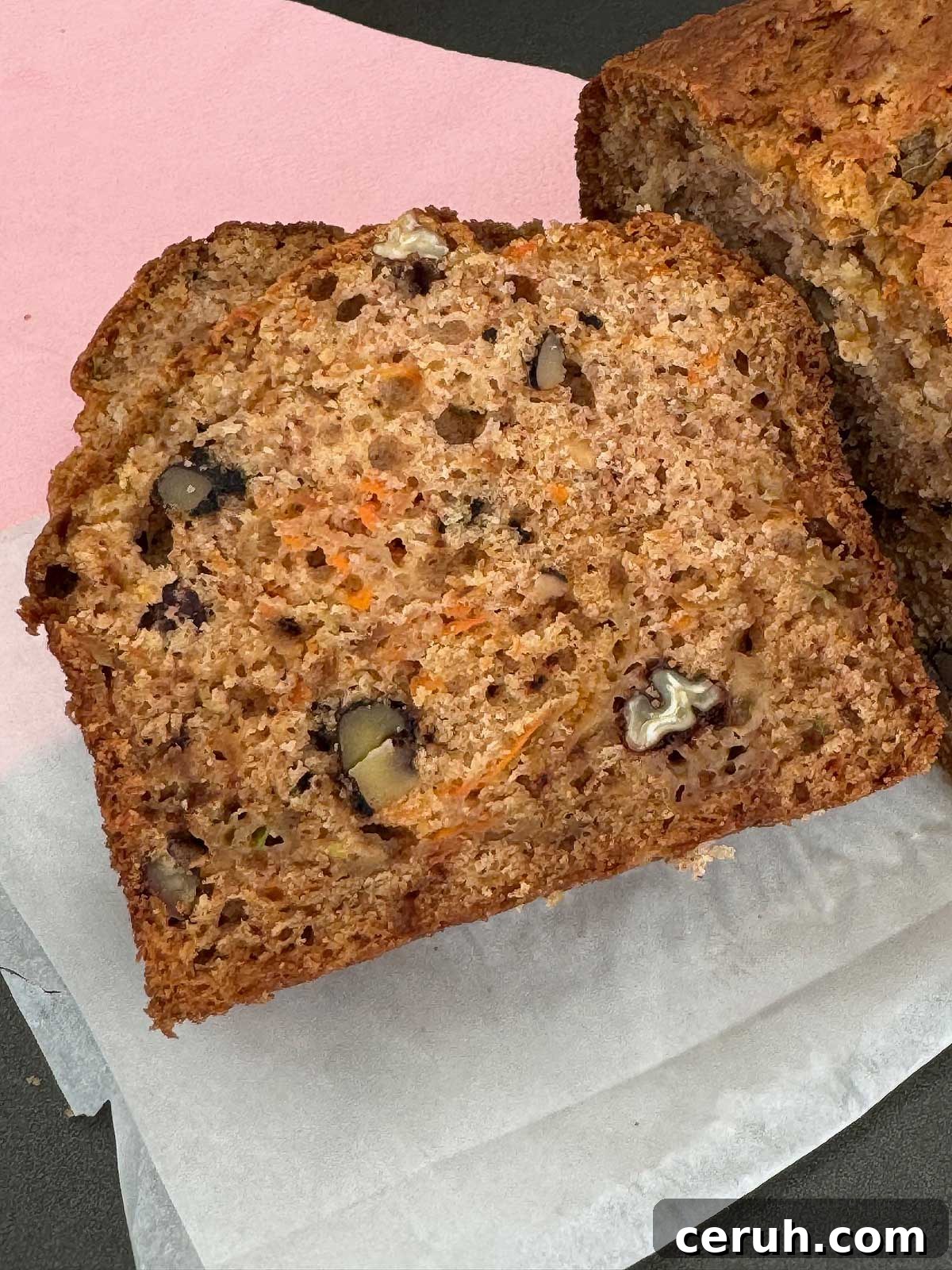 Slice of Sourdough Zucchini Bread showing crumb, carrots and apples.