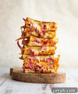 Pickled Onion Grilled Cheese 6 sandwich halves stacked on each other on small wooden board
