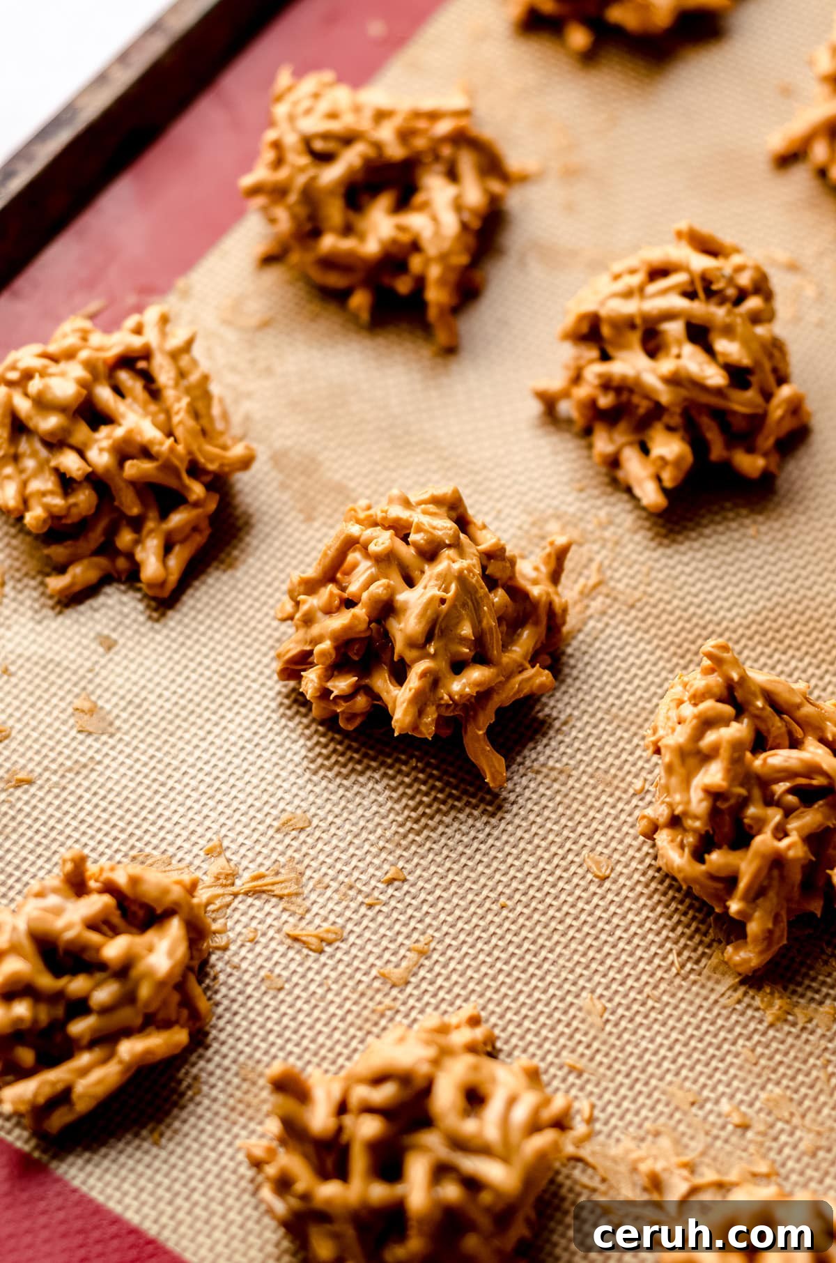 Chewy Butterscotch Haystack Cookies Recipe for Crowd-Pleasing Treats 12 A silicone baking mat with mounts of no bake cookies on it.