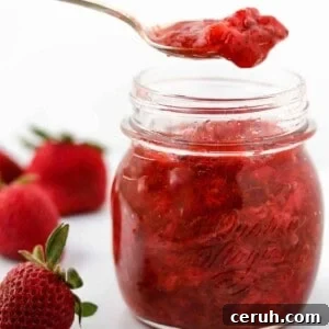Strawberry Rhubarb Compote Recipe: Quick Homemade Fruit Sauce 14 Close up of Strawberry Rhubarb Compote in a jar with a spoon.