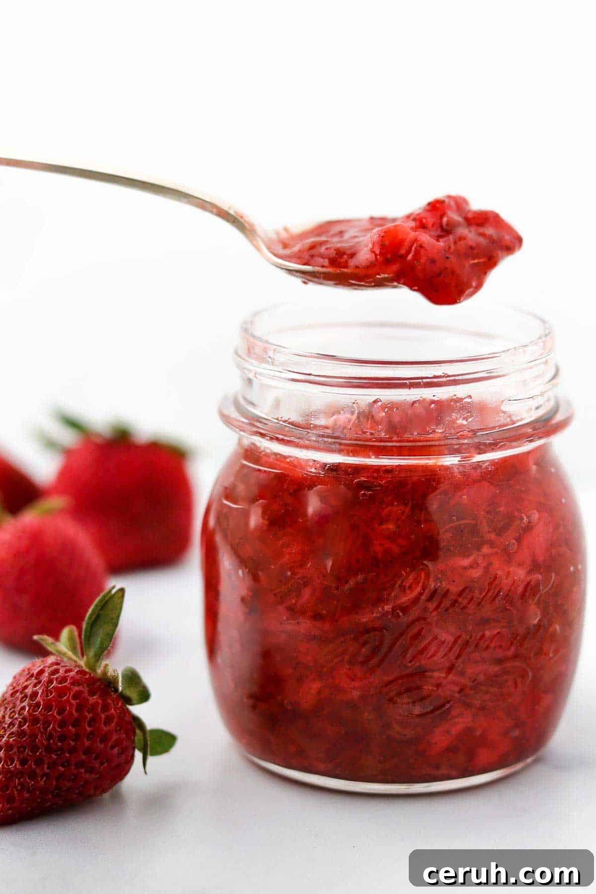 Strawberry Rhubarb Compote Recipe: Quick Homemade Fruit Sauce 9 Strawberry Rhubarb Compote on a spoon over a jar.