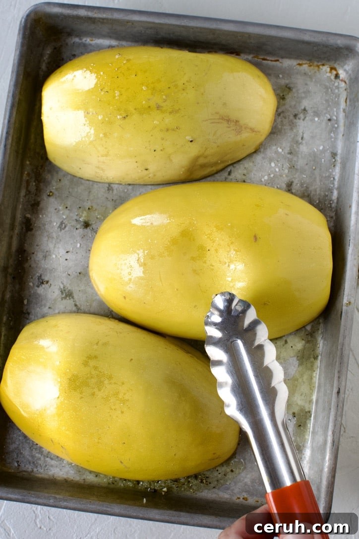 Roast Spaghetti Squash, after cooking, testing for doneness by pressing the skin. It is done when it leaves a dent, as seen.