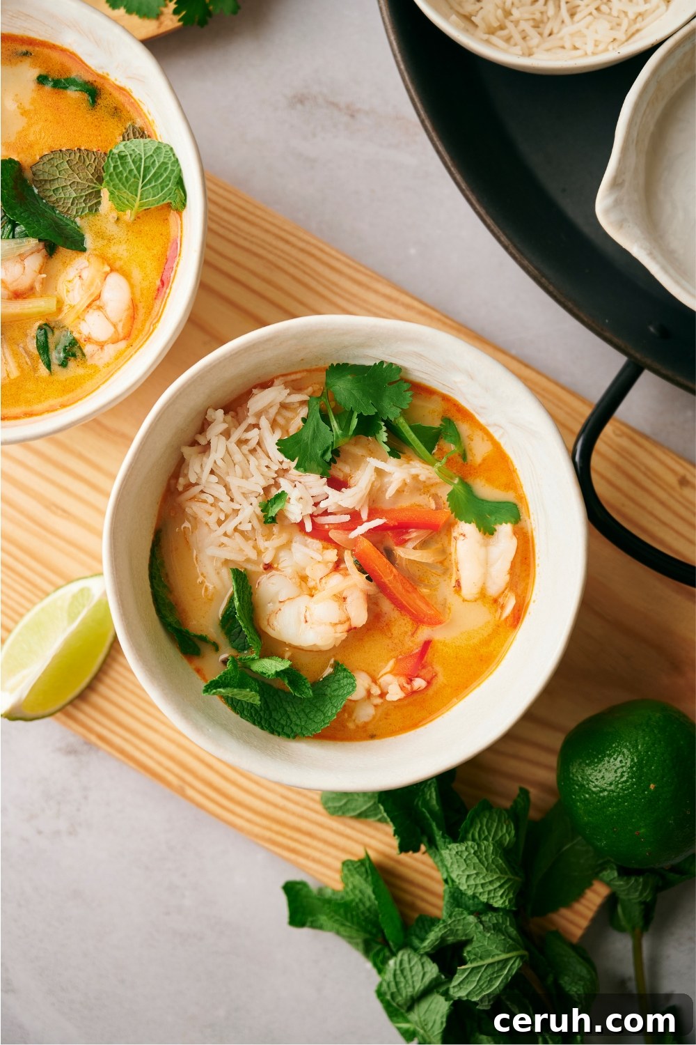 Rice, shrimp, and red bell peppers in a bowl of soup,.