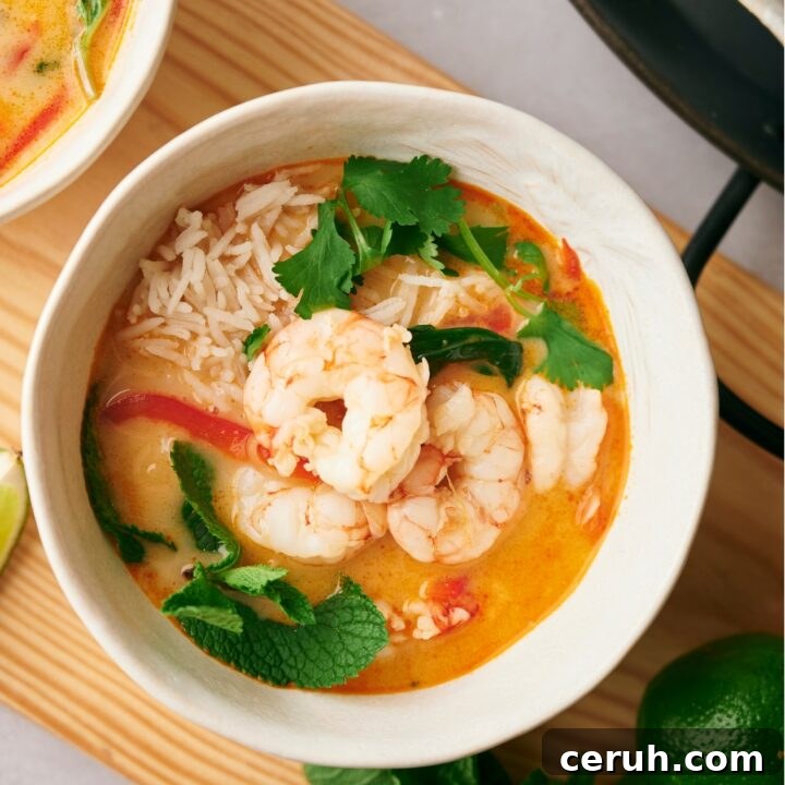 Shrimp on top of broth in a white bowl.