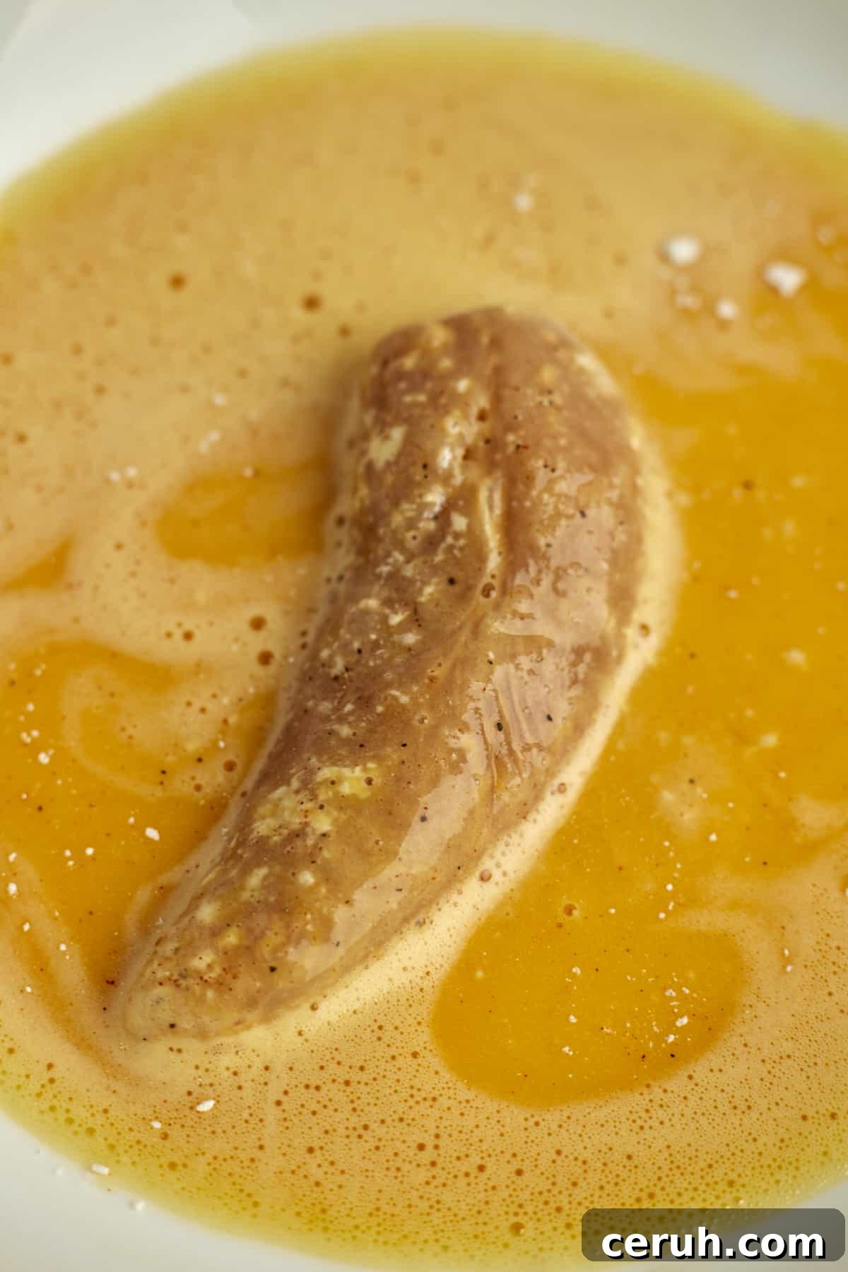 a chicken tender dipped in an egg wash