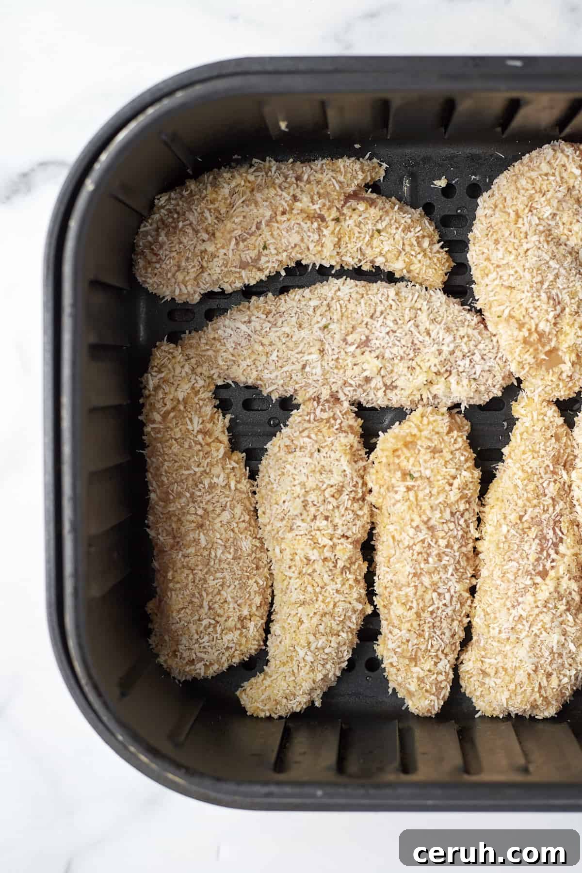 raw coconut chicken tenders in an air fryer
