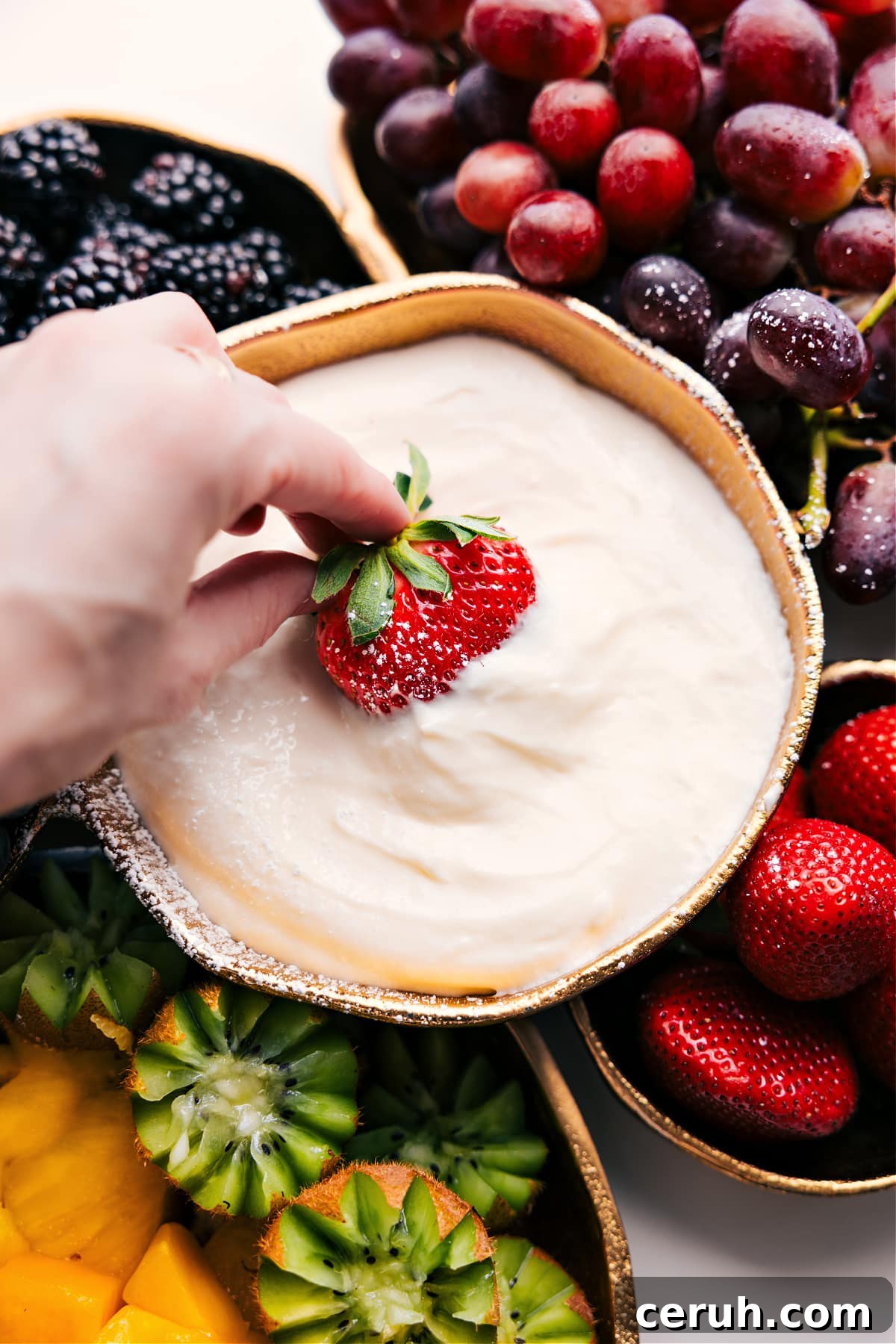 Cream Cheese Fruit Dip Recipe with a strawberry being dipped in.