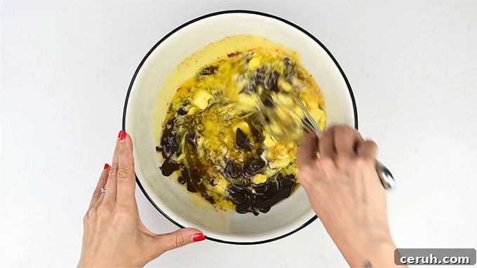 stirring chocolate and melted butter together in a bowl