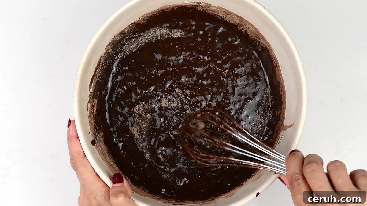 stirring brownie batter in a bowl