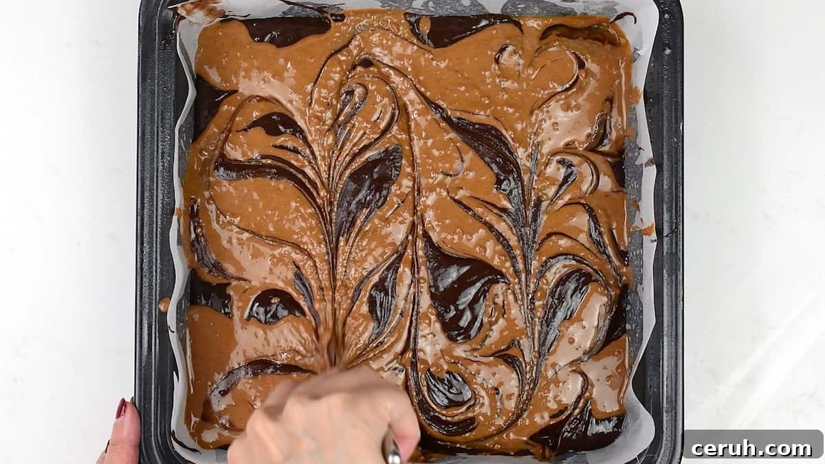 swirling Biscoff spread into brownie batter using a knife