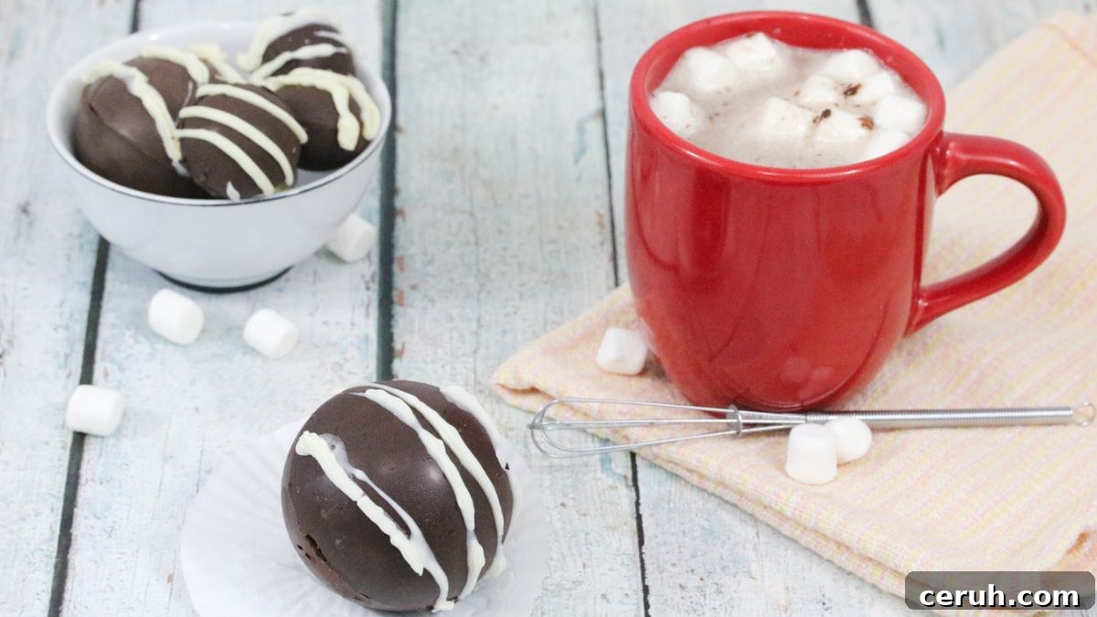 Hot chocolate bomb with white icing with a red cup of hot chocolate and marshmallows behind it.