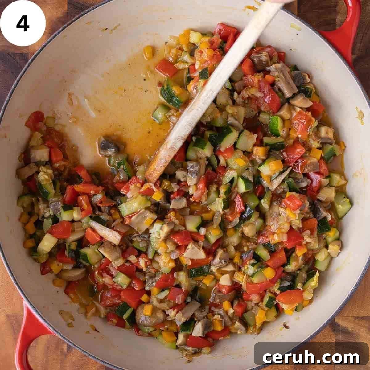 Stirring a cooked mixture of vegetables in a skillet.