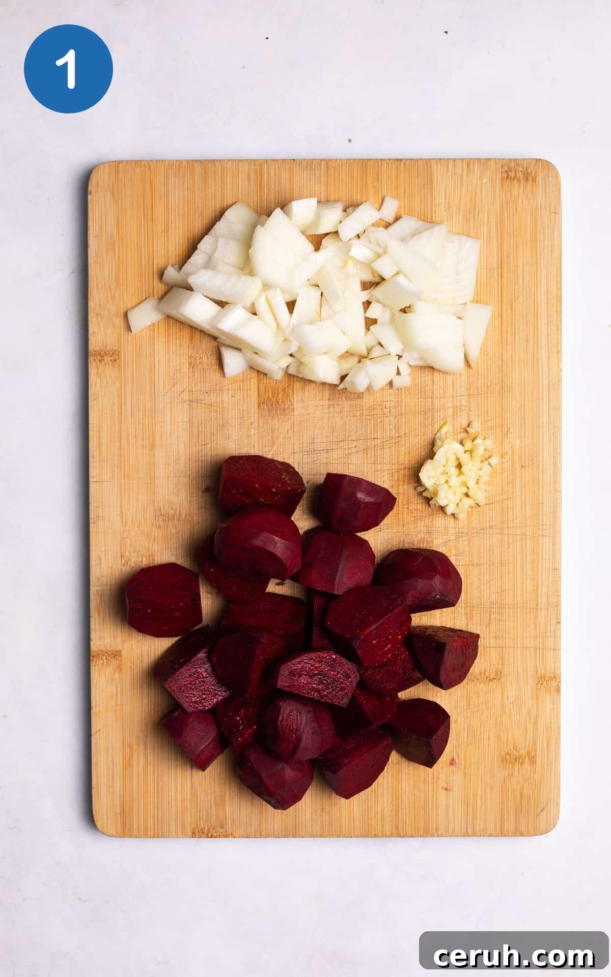 onion, garlic and beetroots on a wooden cutting board.