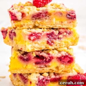 Four raspberry oat bars stacked on top of each other.
