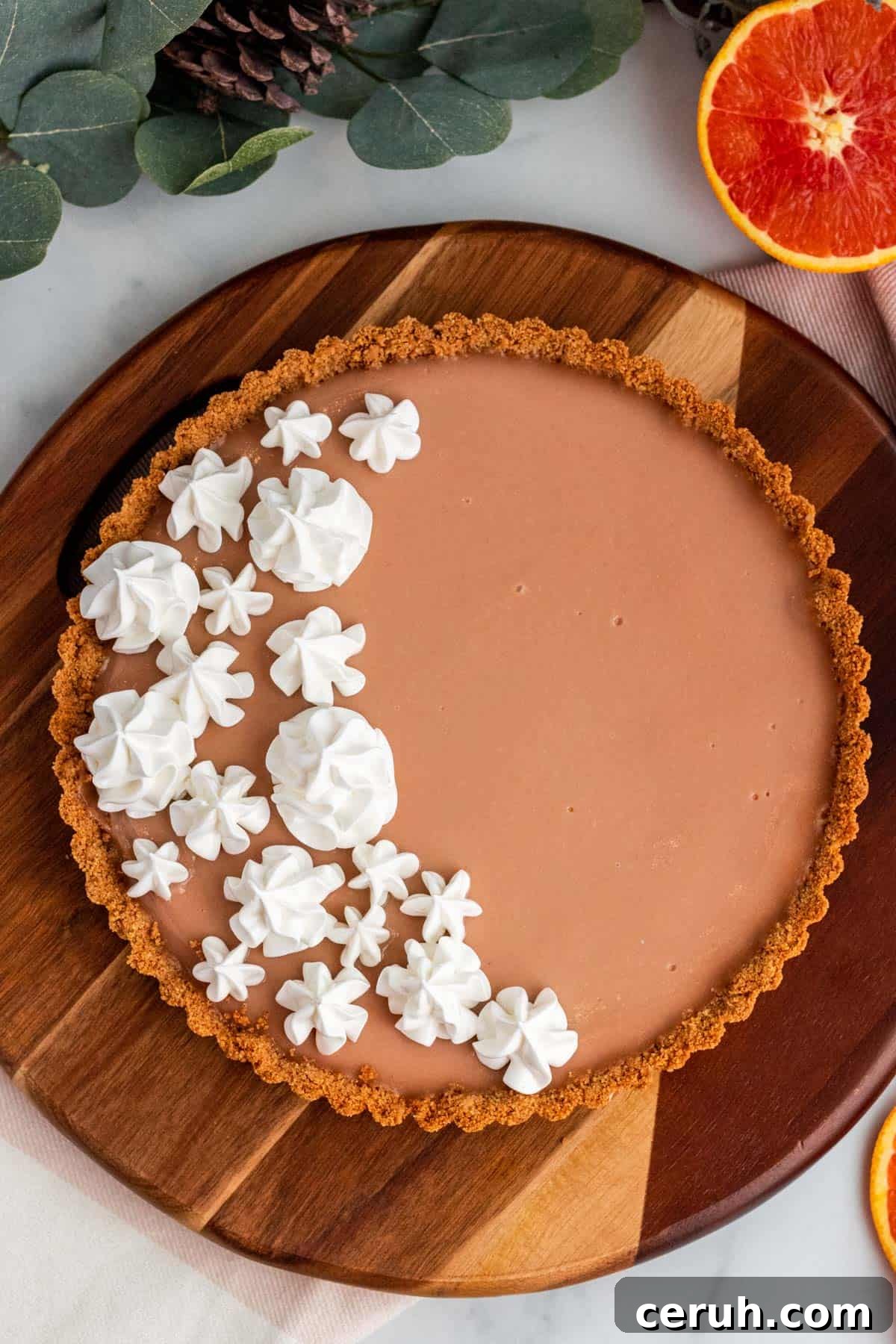 Zesty Blood Orange Tart Recipe with Buttery Shortcrust 2 blood orange tart with meringue on a wood platter with oranges around it