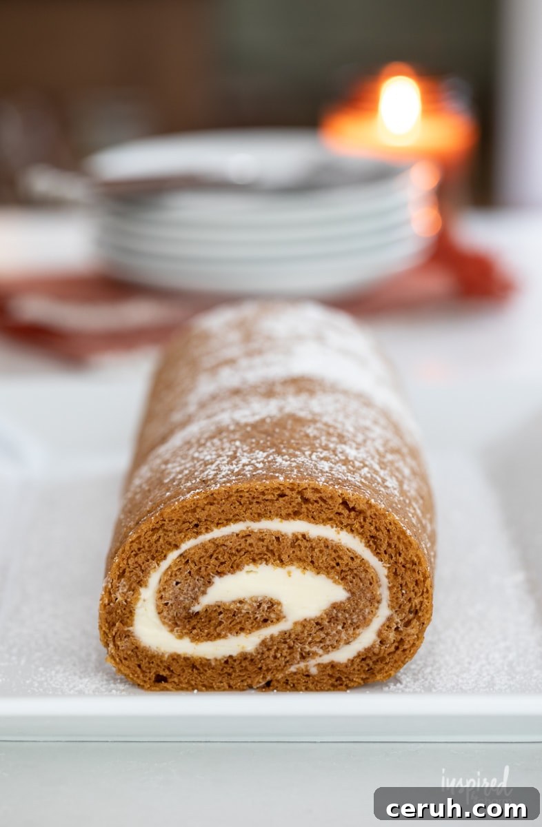 pumpkin roll on a plate on a kitchen counter.