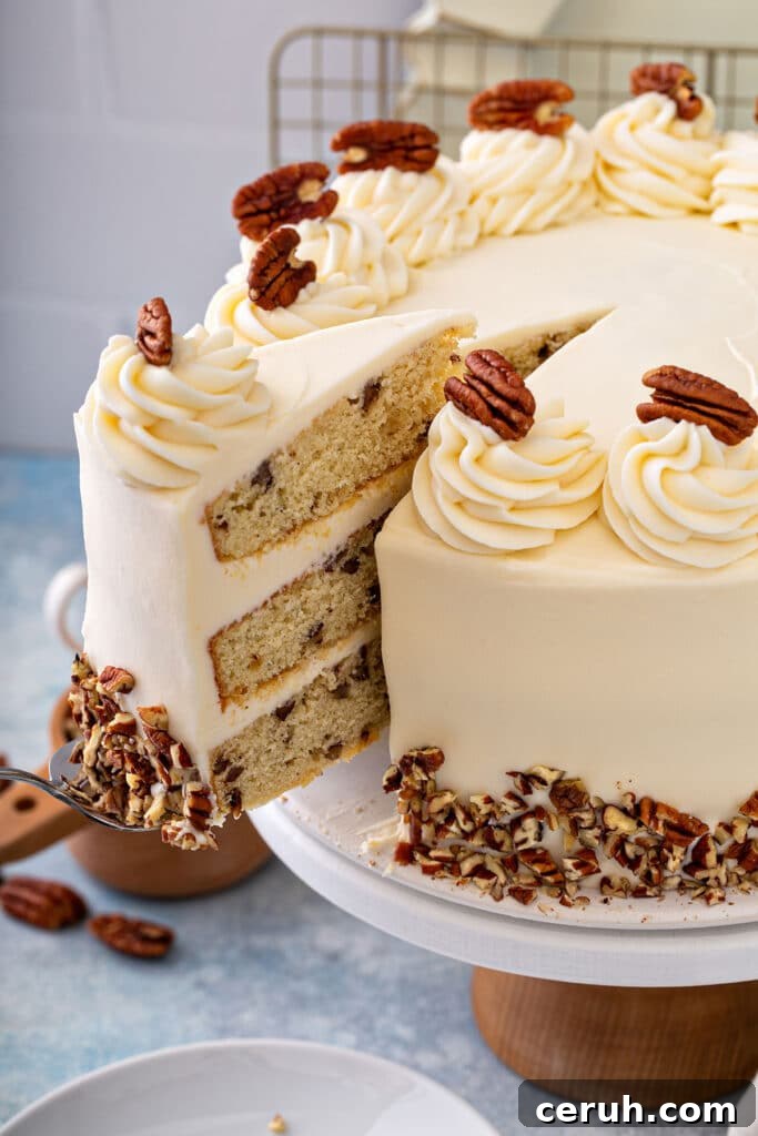 A slice of butter pecan cake getting lift from a cake platter