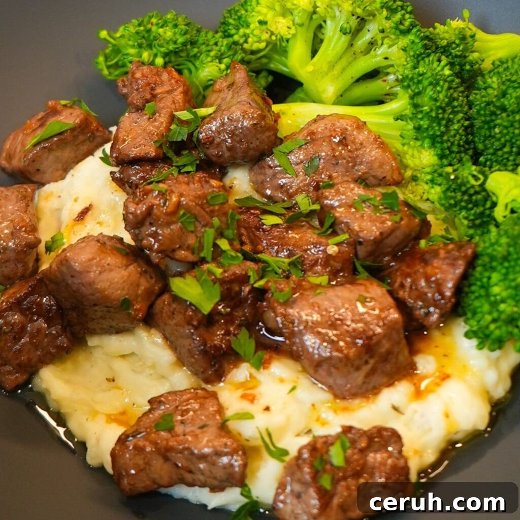 Juicy garlic butter steak bites over mashed potatoes.