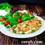 A spinach onelet on a white plate with a spinach salad.