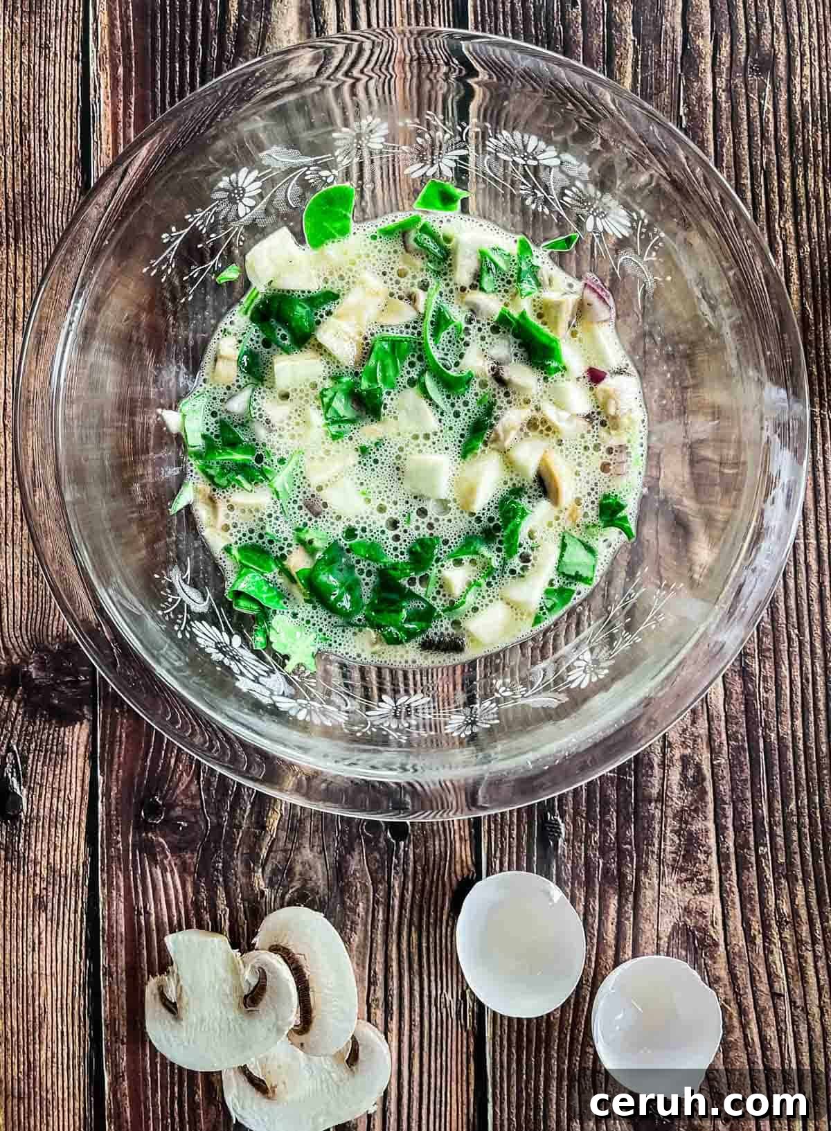 Ingredients for the omelette whisked together in a glass bowl.